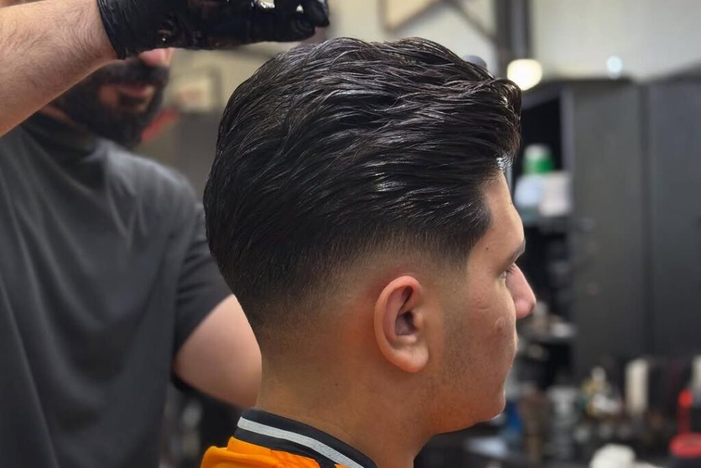 A barber at Aliana Barbershop working on a fresh taper