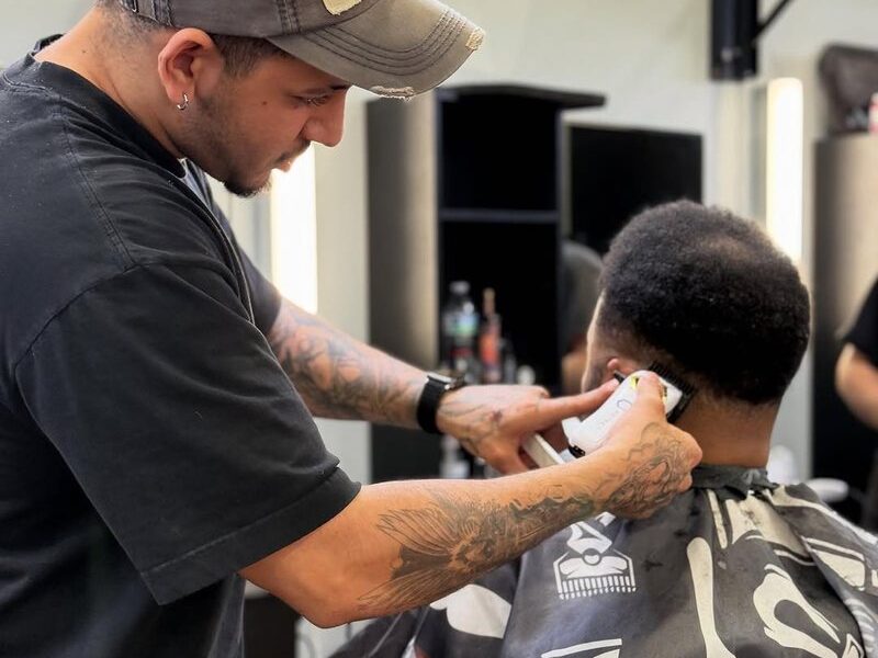 An Aliana barber working clippers along the neckline of a client's cut