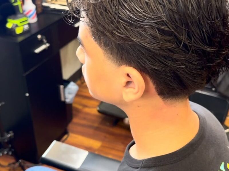 A fresh textured cut on a client in an Aliana Barbershop chair